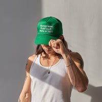 A man wearing the Rooted Plant Club Trucker Hat in green.